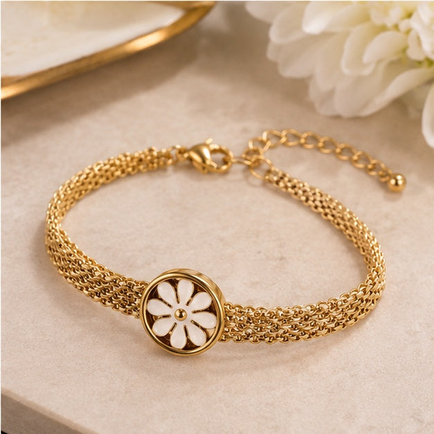 Close-up lifestyle detail of gold-tone daisy mesh bracelet