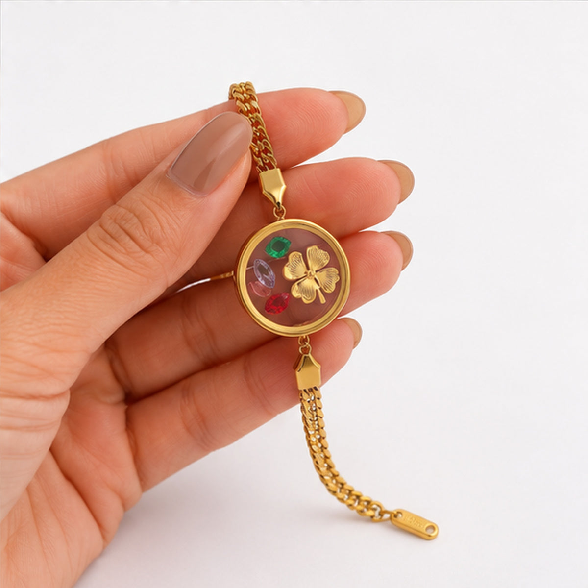 Floral charm gold bracelet held in hand detail