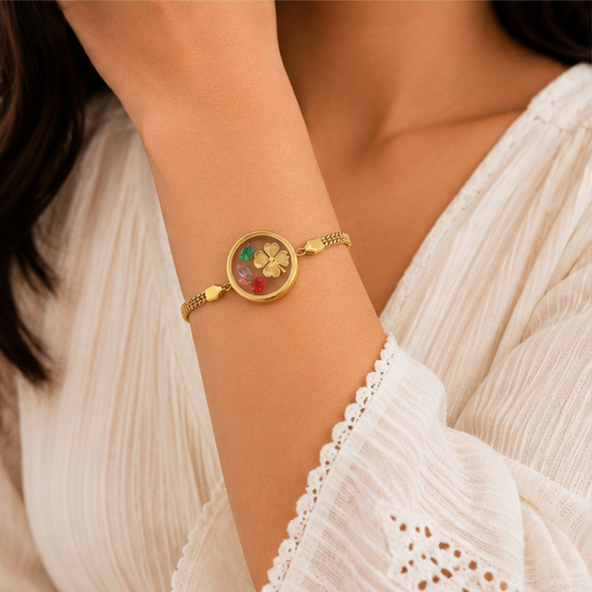 Floral charm gold bracelet worn on wrist