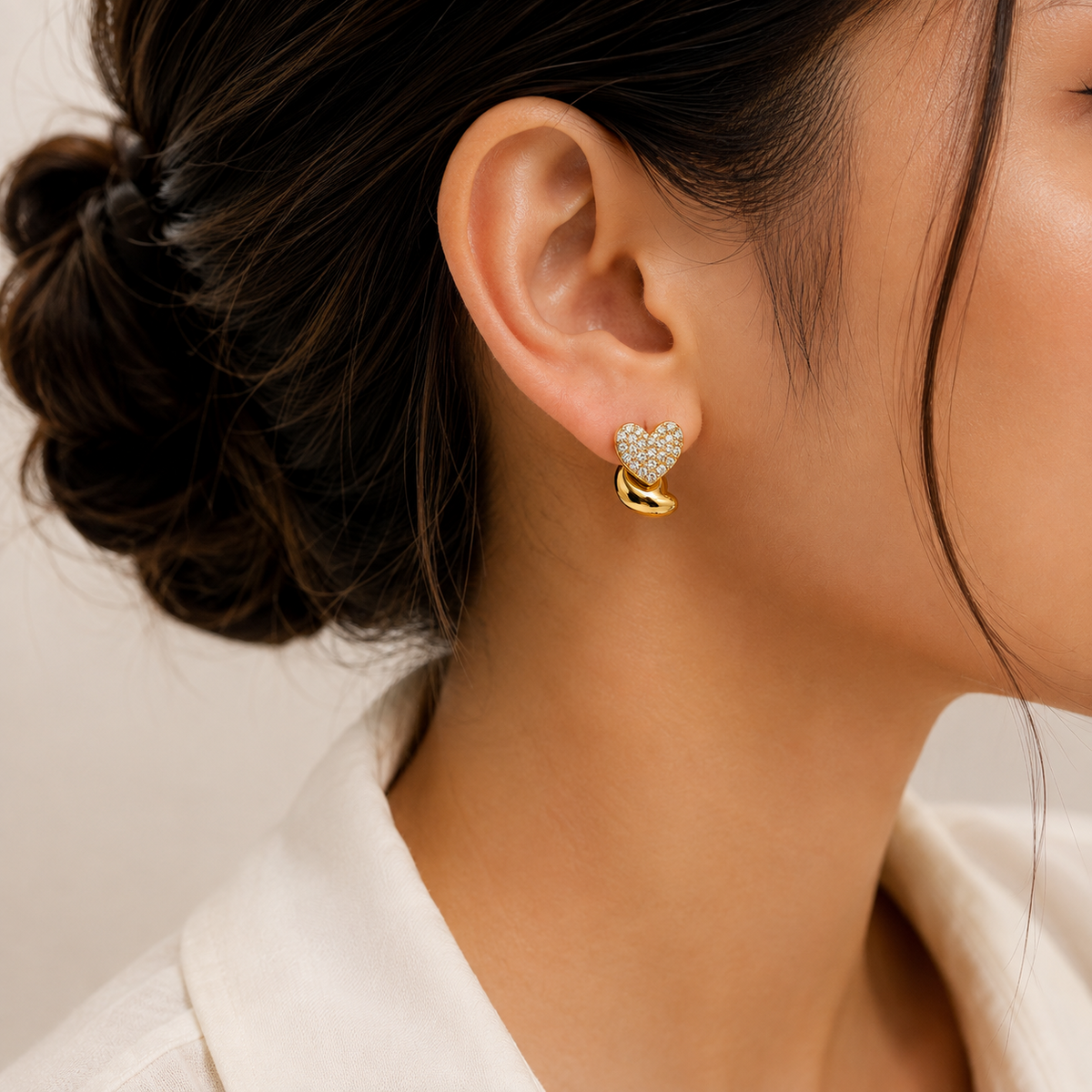 PRISA Gold Heart Crystal Stud Earrings held in hand