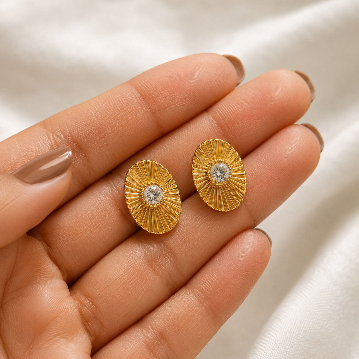 PRISA Radiant Sunburst Stud Earrings held in hand