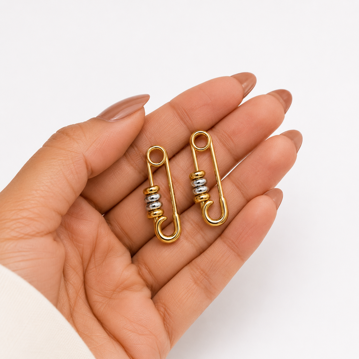 PRISA Gold Safety Pin Statement Earrings held in hand