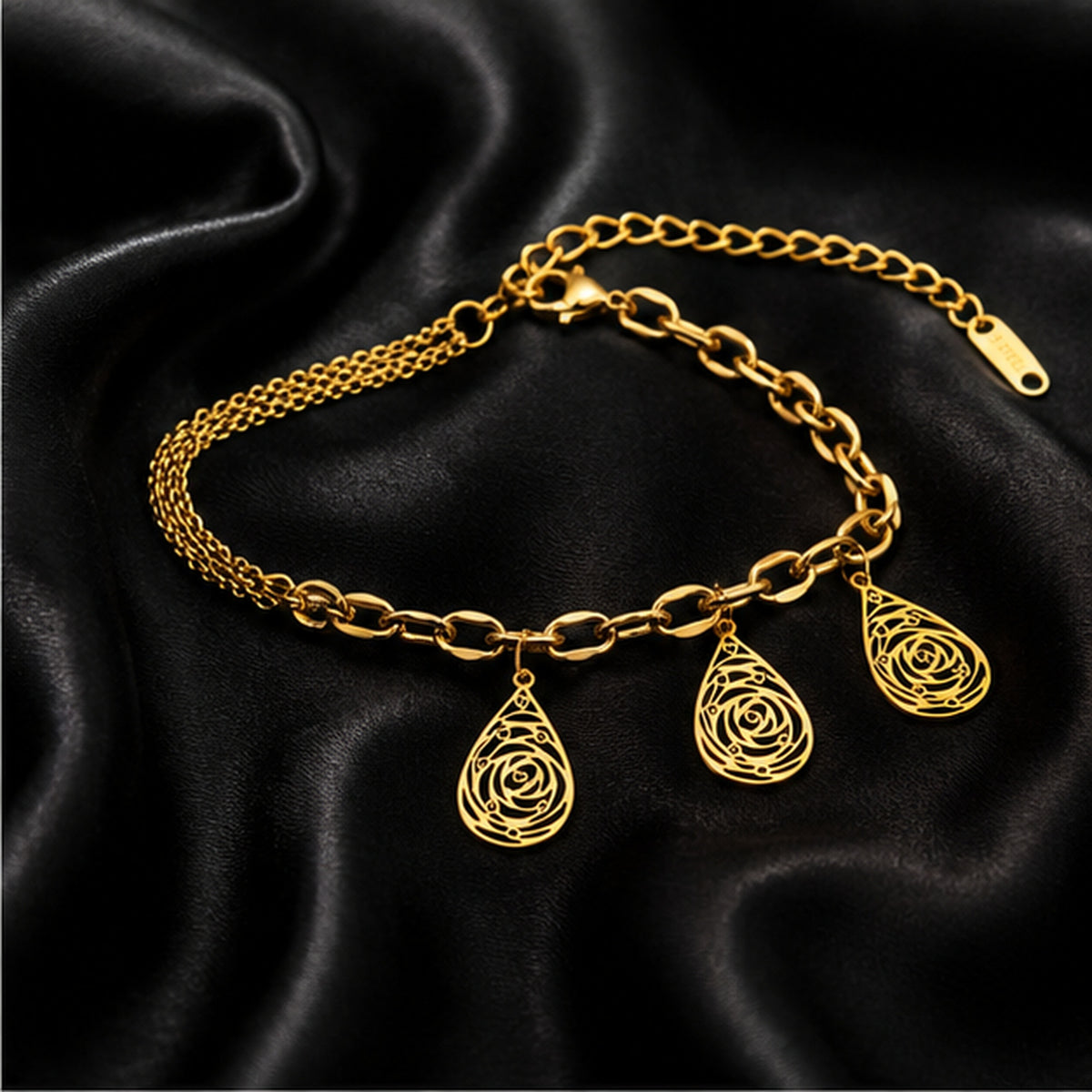 Gold teardrop filigree charm bracelet on black satin