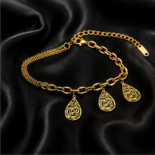 Gold teardrop filigree charm bracelet on black satin