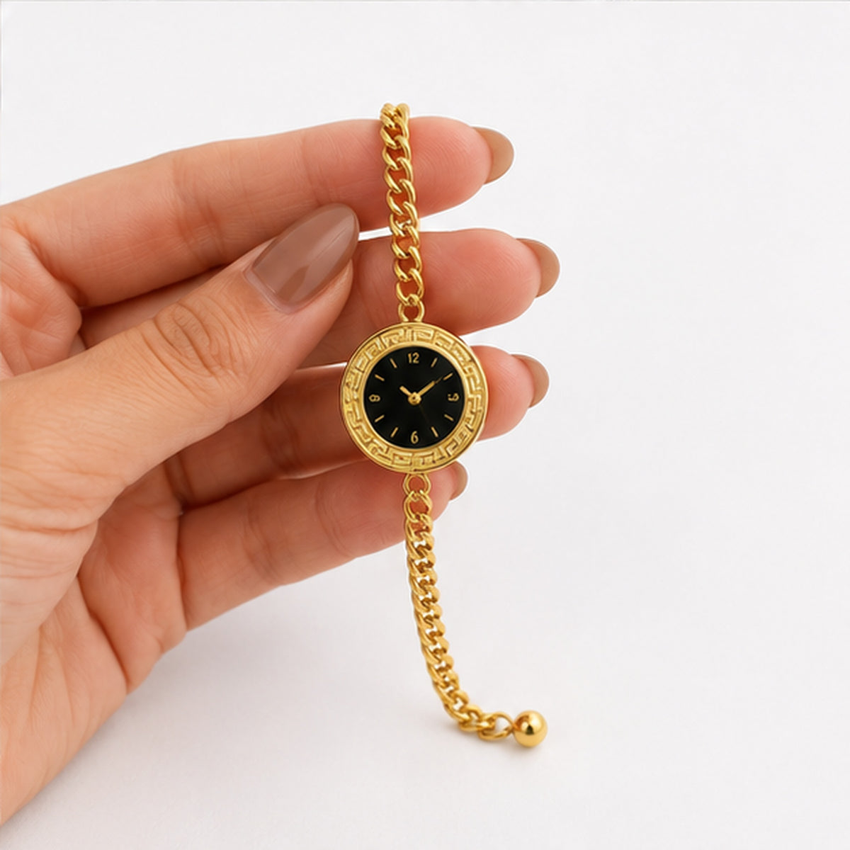 Gold watch-style bracelet held in hand